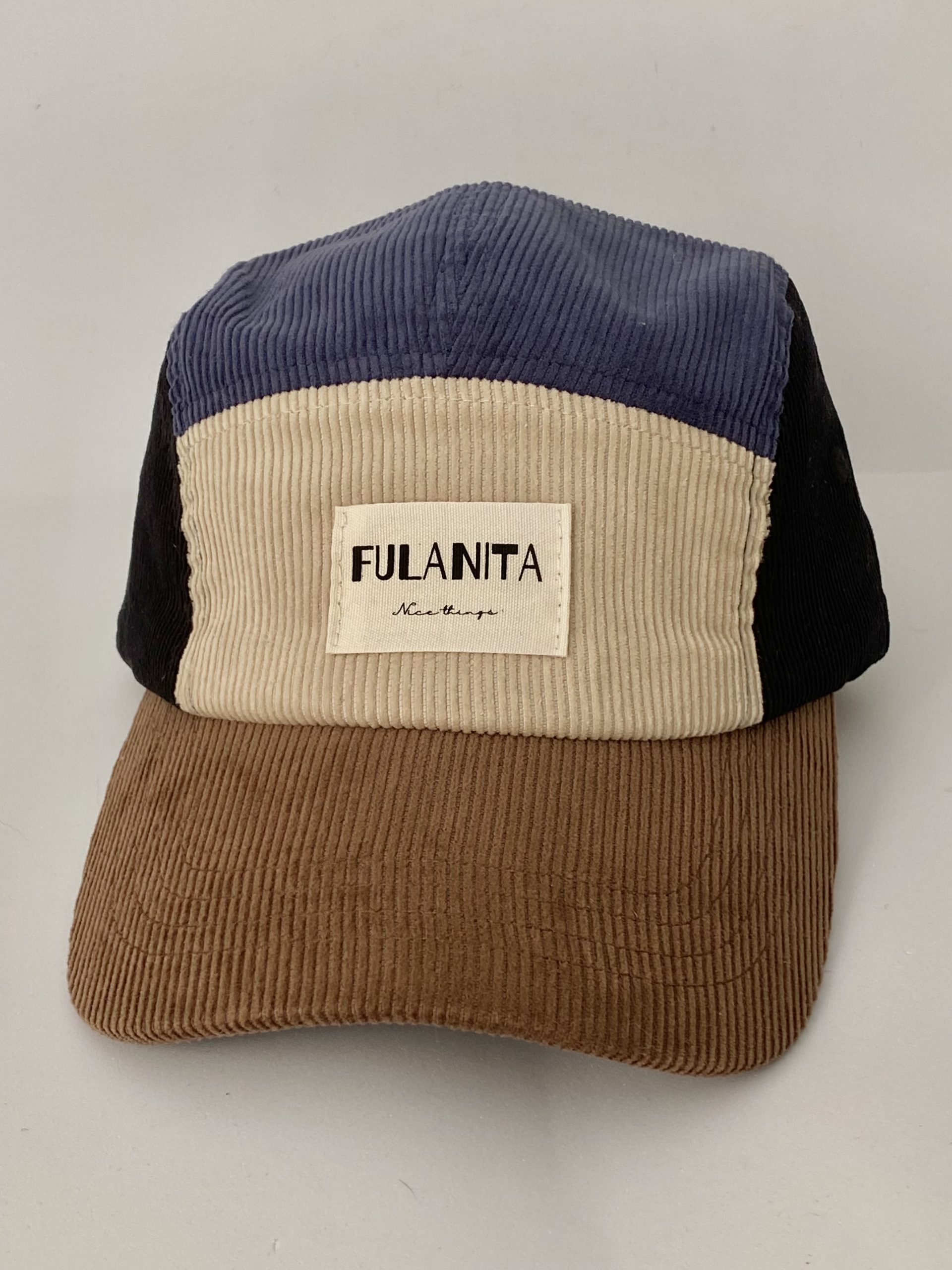 Gorra de pana color block sobre fondo neutro