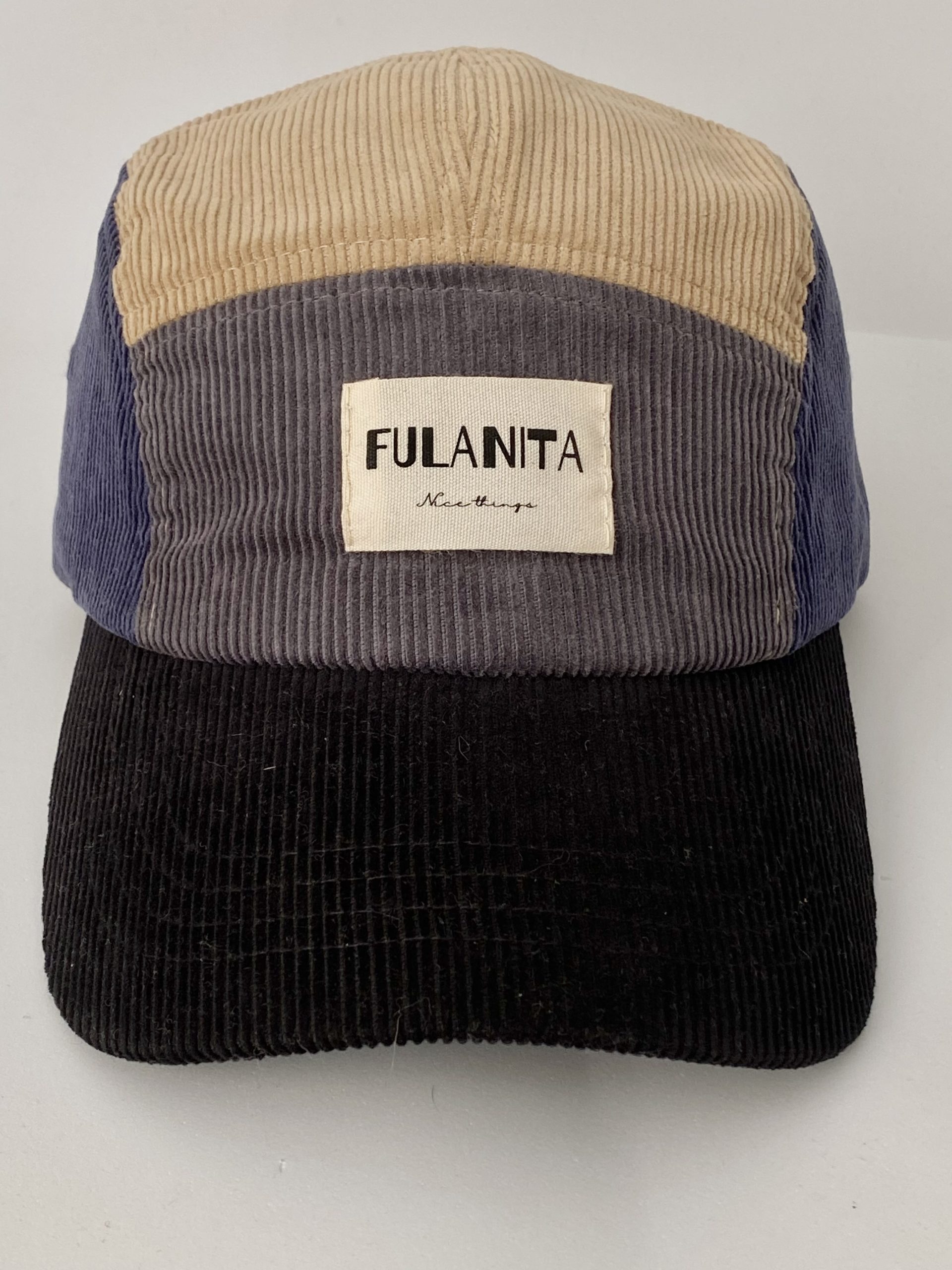 Gorra de pana color block sobre fondo neutro