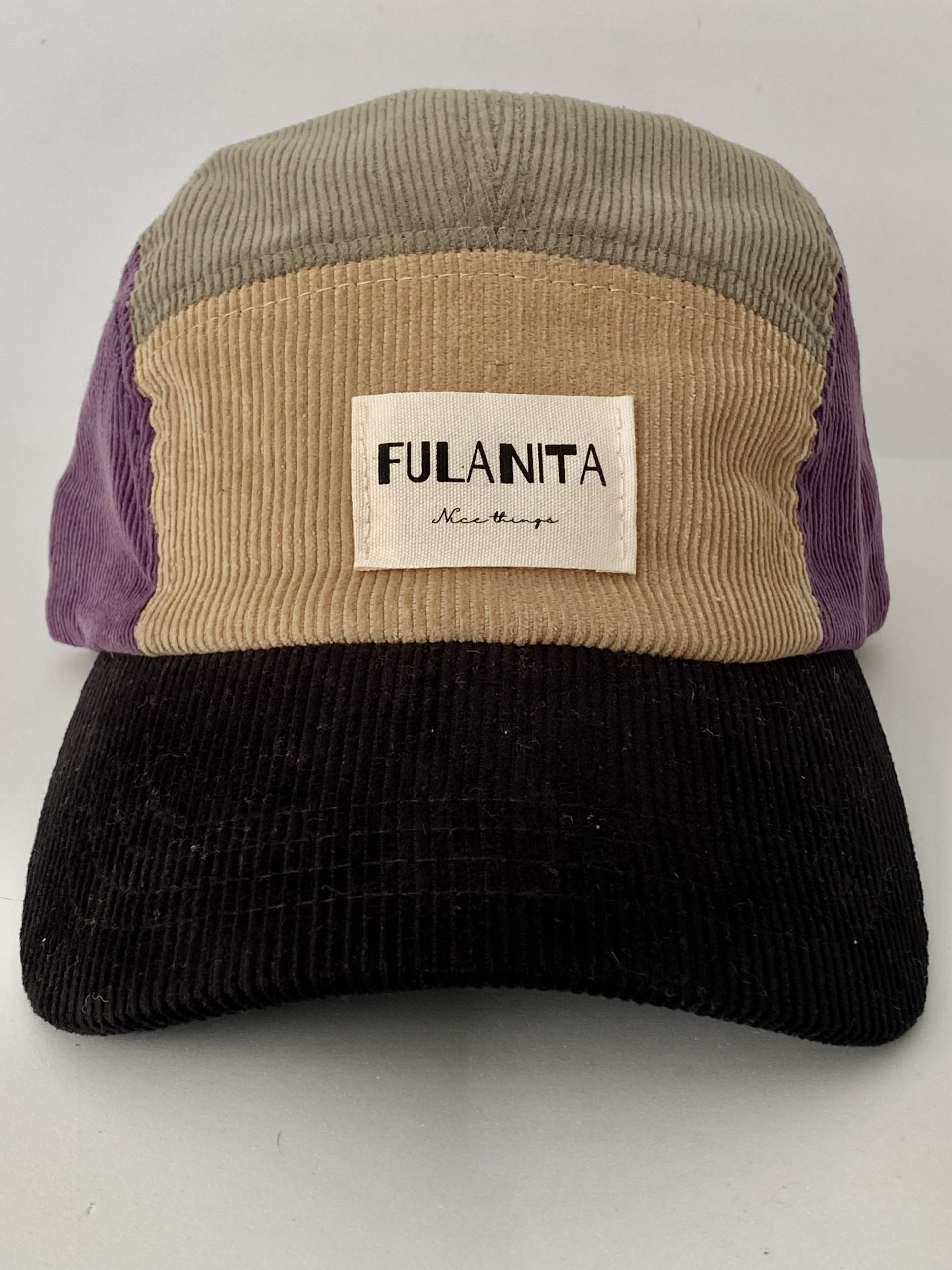 Gorra de pana color block sobre fondo neutro