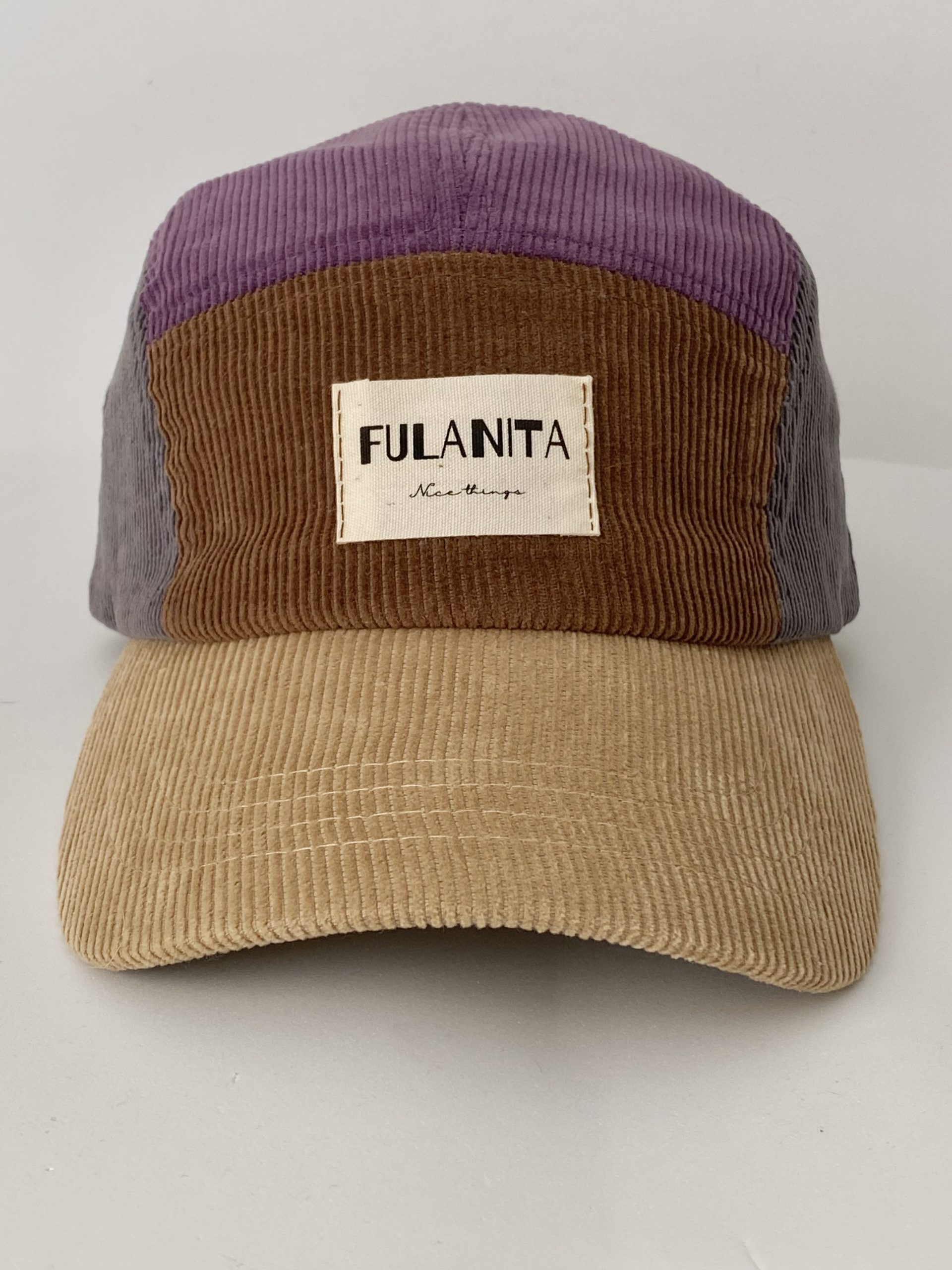Gorra de pana color block sobre fondo neutro