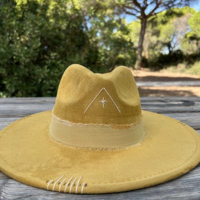 Sombrero mostaza Nature One of a Kind con bordado beige en forma de triángulo en el frontal y grabados decorativos.